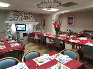 une salle à manger avec des tables et des chaises rouges et une cheminée dans l'établissement Chalet Saint Louis, à Lourdes