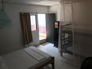 Palomino Hostel في بالومينو: غرفة صغيرة بها سرير ونافذة