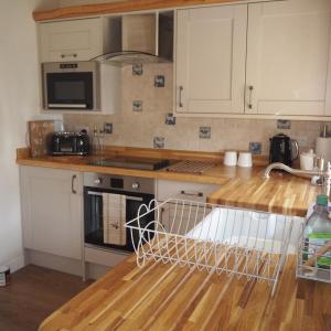 a kitchen with white cabinets and a counter top at The Tack Room Cottage in Blandford Forum