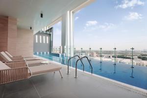 a swimming pool with a balcony overlooking the ocean at Millennium Montrose Hotel Apartment in Dubai