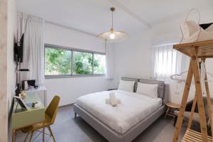 a bedroom with a bed and a desk and a chair at 36 Geula - By Beach Apartments TLV in Tel Aviv