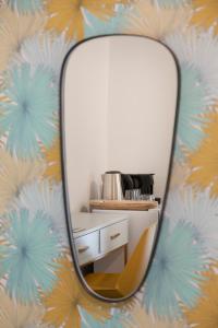 a mirror in a room with a dresser and a chair at 36 Geula - By Beach Apartments TLV in Tel Aviv