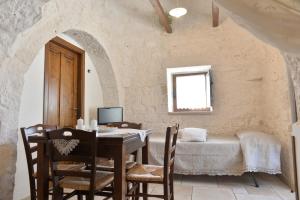 um quarto com uma mesa e cadeiras e uma cama em I Trulli Del Nonno Michele em Alberobello