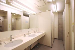 a bathroom with two sinks and a mirror at Sakura Hostel Asakusa in Tokyo