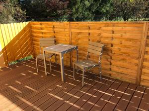 twee stoelen en een tafel op een houten terras bij Apartmány LETO in Frýdek-Místek