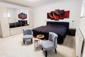 a bedroom with a bed and two chairs and a table at Rosenchalet in Leinach