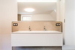 ein Bad mit einem Waschbecken und einem Spiegel in der Unterkunft Rosenchalet in Leinach