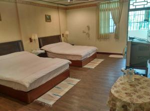 Zimmer mit 2 Betten und TV in der Unterkunft Coffee Street Homestay in Gukeng
