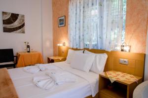 a bedroom with a white bed with two towels on it at Maik Apartments in Metamorfosi