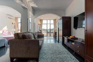 a living room with a couch and a bed and a television at Pousada de Coloane Boutique Hotel in Macau