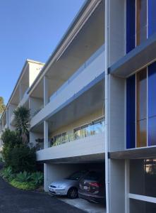 a building with a car parked in the parking lot at Central Howick Uxbridge Apartments in Auckland