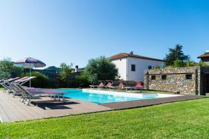 a swimming pool with chairs and a table and an umbrella at Simona Villa - Private Pool in Omignano Scale