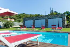 a swimming pool with red chairs and a group at Simona Villa - Private Pool in Omignano Scale