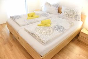 two beds with white and yellow pillows on them at Haus Konny in Schladming