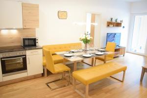 シュラートミンクにあるHaus Konnyのキッチン、ダイニングルーム(テーブル、黄色い椅子付)