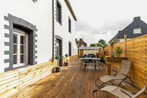 une terrasse en bois avec une table et des chaises sur une maison dans l'établissement Osemae Immobilier - Redon Port-Chatelêt, à Redon