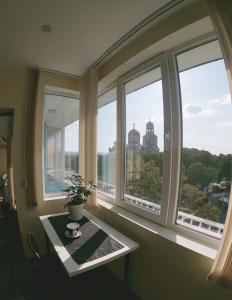 a room with windows with a table and a view of a building at By the CATHEDRAL · TOP center · 2 Bedroom FLAT in Varna City