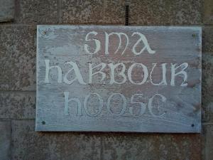 un panneau sur le côté d'un mur de briques dans l'établissement Sma Harbour Hoose, à Gourdon