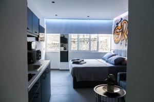 a small bedroom with a bed and a kitchen at Triple A - Graffiti Homage in Psirri Square - FREE Parking! in Athens