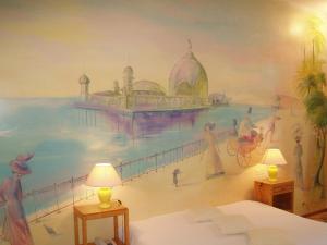 a bedroom with a mural of a beach at Le Windsor, Jungle Art Hotel in Nice