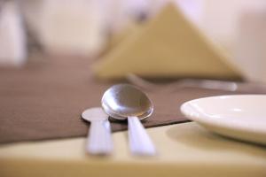 a spoon sitting on a table next to a plate at Hotel Pushkar Legacy in Pushkar