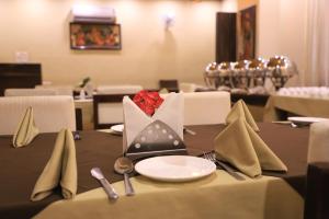 a table with napkins and utensils on top of a table at Hotel Pushkar Legacy in Pushkar