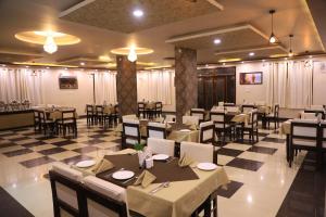 a restaurant with tables and chairs in a room at Hotel Pushkar Legacy in Pushkar