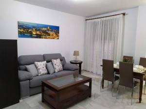 - un salon avec un canapé et une table dans l'établissement Precioso apartamento en el Arenal, à Séville