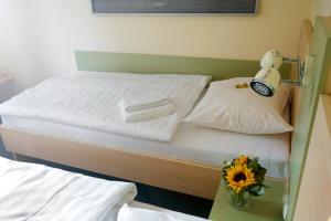 a bedroom with a bed with a flower on a table at Best Deal Airporthotel Weeze in Weeze