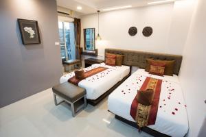a hotel room with two beds and a chair at Pongsakorn Boutique Resort in Lat Krabang