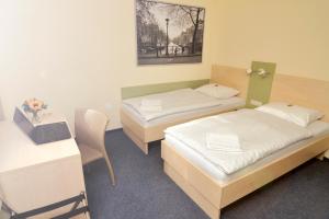 a room with two beds and a desk with a laptop at Best Deal Airporthotel Weeze in Weeze