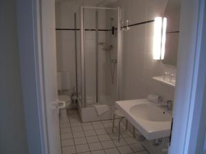 a bathroom with a shower and a sink and a toilet at Landgasthof Pleister Mühle in Münster