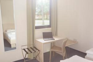 a white desk with a laptop on it in a room at Best Deal Airporthotel Weeze in Weeze