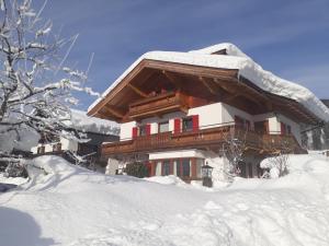 a house covered in snow in front at Haus Erika in Brixen im Thale