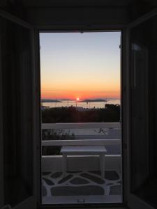 una ventana con vistas a la puesta de sol en White Myth, en Mykonos ciudad