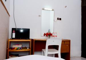 1 dormitorio con escritorio, ordenador y silla blanca en Fortuna Guest House, en Yogyakarta