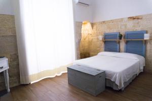Schlafzimmer mit einem Bett mit blauem Kopfteil in der Unterkunft Donato Rooms in Trani