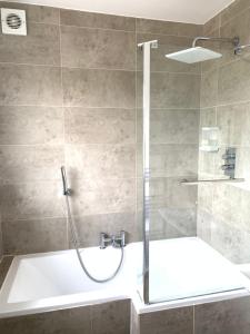 a bathroom with a shower with a tub and a sink at Great Airport Sleep in Harmondsworth