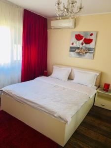 ガラツィにあるAmbiance studioのベッドルーム1室(赤いカーテン付きの白いベッド1台付)