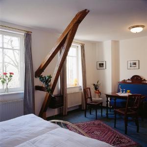 Schlafzimmer mit einem Bett, einem Tisch und einem Fenster in der Unterkunft Landgasthof Pleister Mühle in Münster