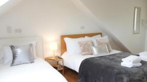 a bedroom with two beds with white sheets and pillows at The great airport place-private bedrooms with private bathroom-1 Bus to Heathrow Airport-5 minutes by car- Helpful advice from our team in Harmondsworth