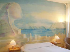 a bedroom with a painting of a statue on the wall at Le Windsor, Jungle Art Hotel in Nice