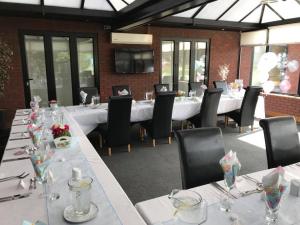 a dining room with long tables and chairs at Calderfields Golf & Country Club in Walsall