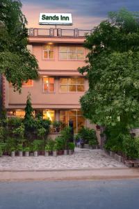 a pink building with a sign that readsaris inn at Sands INN Hotel in Gurgaon