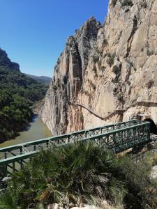 un puente sobre un río junto a una montaña en La Casita de Madera, en Ardales