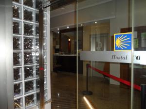 a glass door with a hospital sign in a building at Hostal Coruña in Astorga