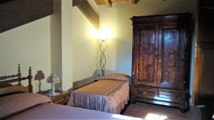 1 dormitorio con 2 camas y armario de madera en Antico Borgo dell'Anconella - rustico appartamento ideale per 2 o 3 persone, en Anconella