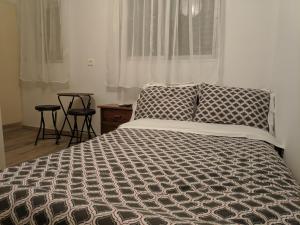 a bedroom with a bed and a window with two stools at Sky line center city Dimitropoulos in Aigio