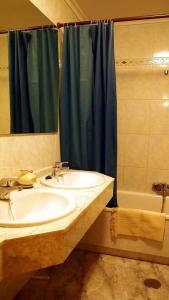 a bathroom with a sink and a blue shower curtain at Casa Azahar in Villalba de la Sierra