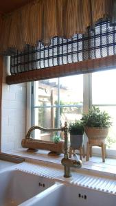 a sink in a kitchen with a window with plants at Casa Azahar in Villalba de la Sierra